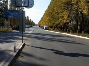 Люди ставят авто вдоль дороги до шлагбаума.
