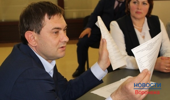 Владимир Нетесов демонстрирует бюллетени для голосования.