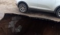 Асфальт провалился рядом со стоящей иномаркой.