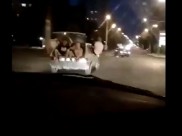 В легковушке ехали несколько парней, сидя вне салона.