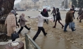 Людям приходится перепрыгивать через лужи.