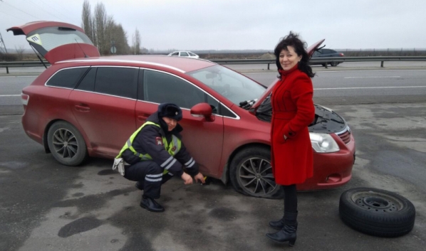 Полицейские помогли женщине поменять колесо.