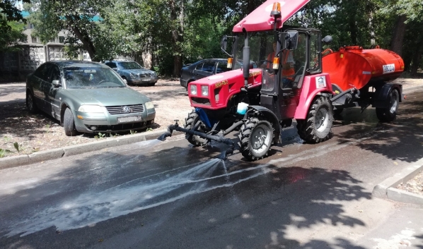 В жару поливают асфальт во дворах.