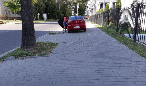 Иномарка стоит на тротуаре.