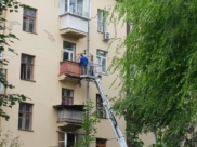 Рабочие демонтируют балкон.