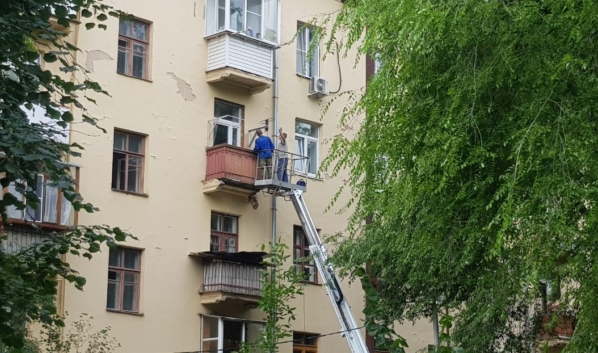 Рабочие демонтируют балкон.