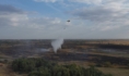 Тлеющие участки заливают водой при помощи вертолета.