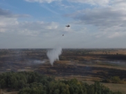 Тлеющие участки заливают водой при помощи вертолета.