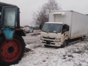 Трактор вытащил грузовик из снежной западни.