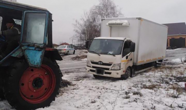 Трактор вытащил грузовик из снежной западни.