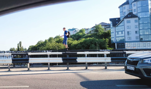 Мужчина гулял по забору на мосту.