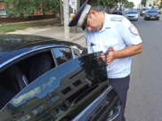 Сотрудник ДПС замеряет светопропускаемость стекла.