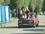 На капоте легковушки везли людей.