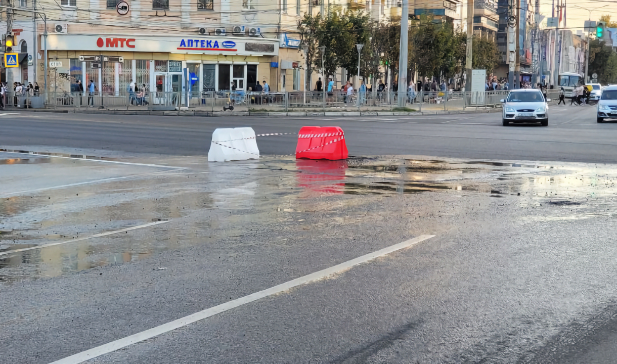 Вода льет из-под земли на дорогу на перекрестке Кольцовской и Плехановской  в Воронеже