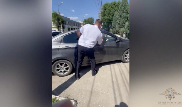 Полицейский разбил стекло запертого авто.